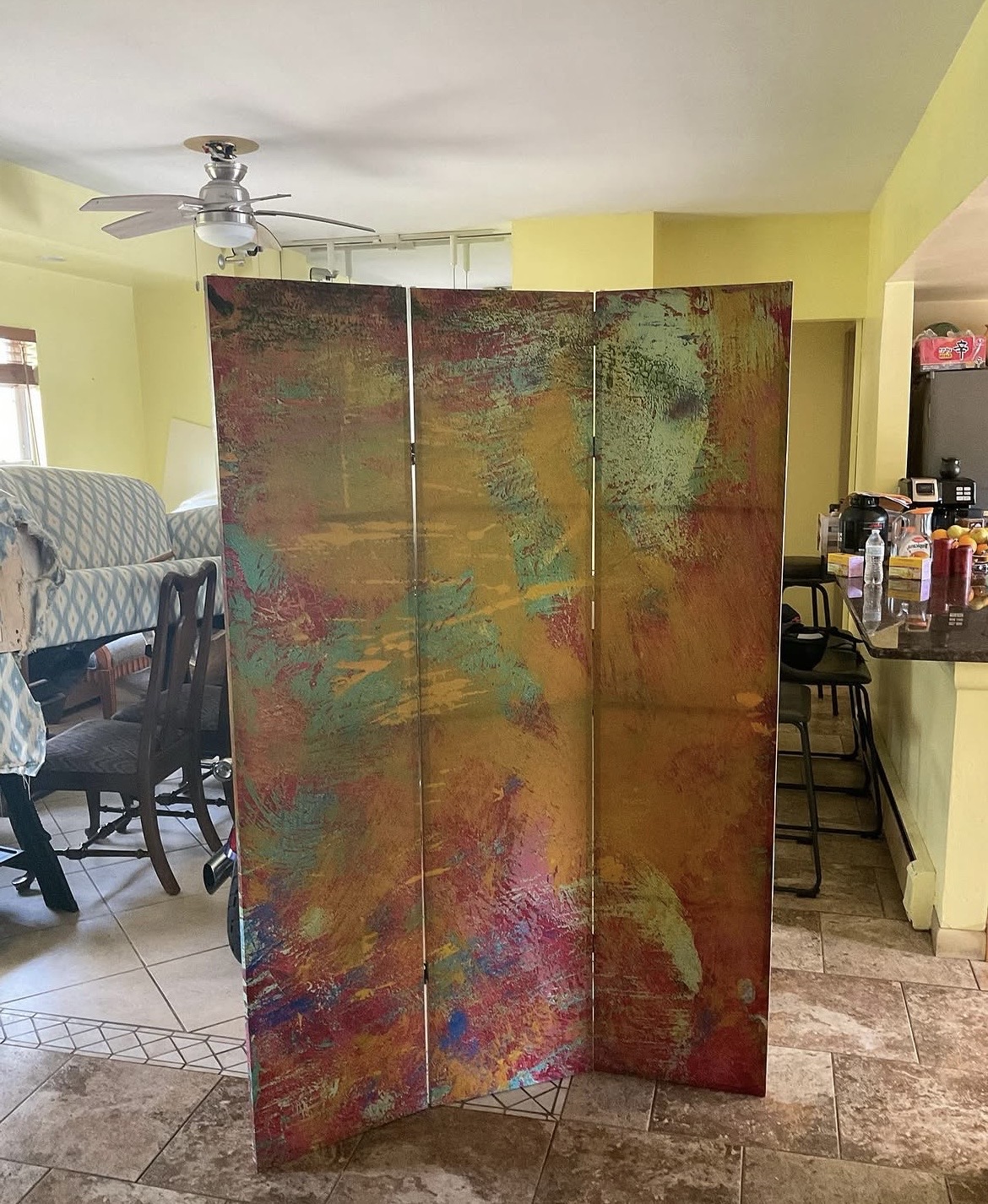 Three-panel room divider before reupholstery — original painted canvas panels