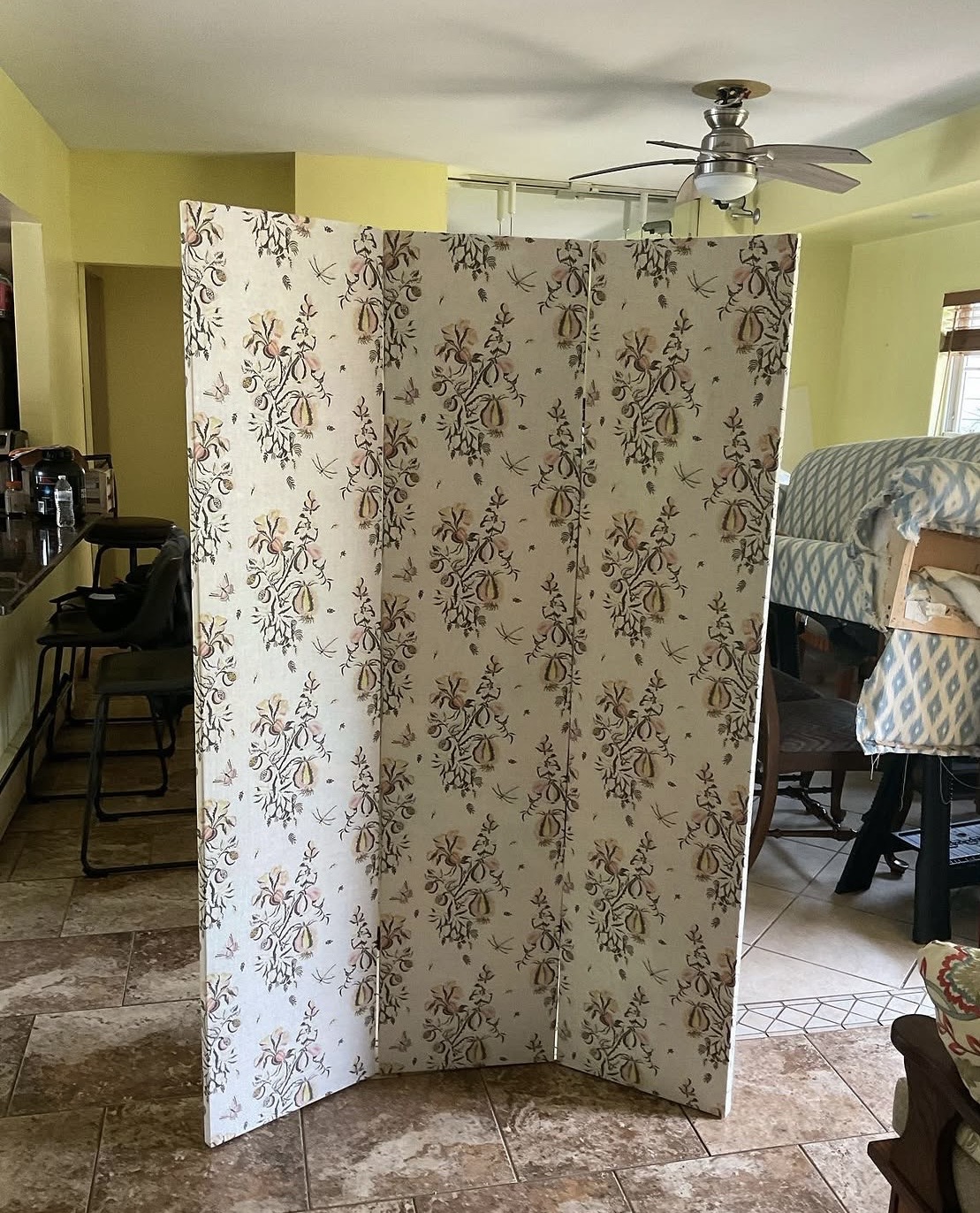 Three-panel room divider after reupholstery — botanical print fabric matched across all three panels