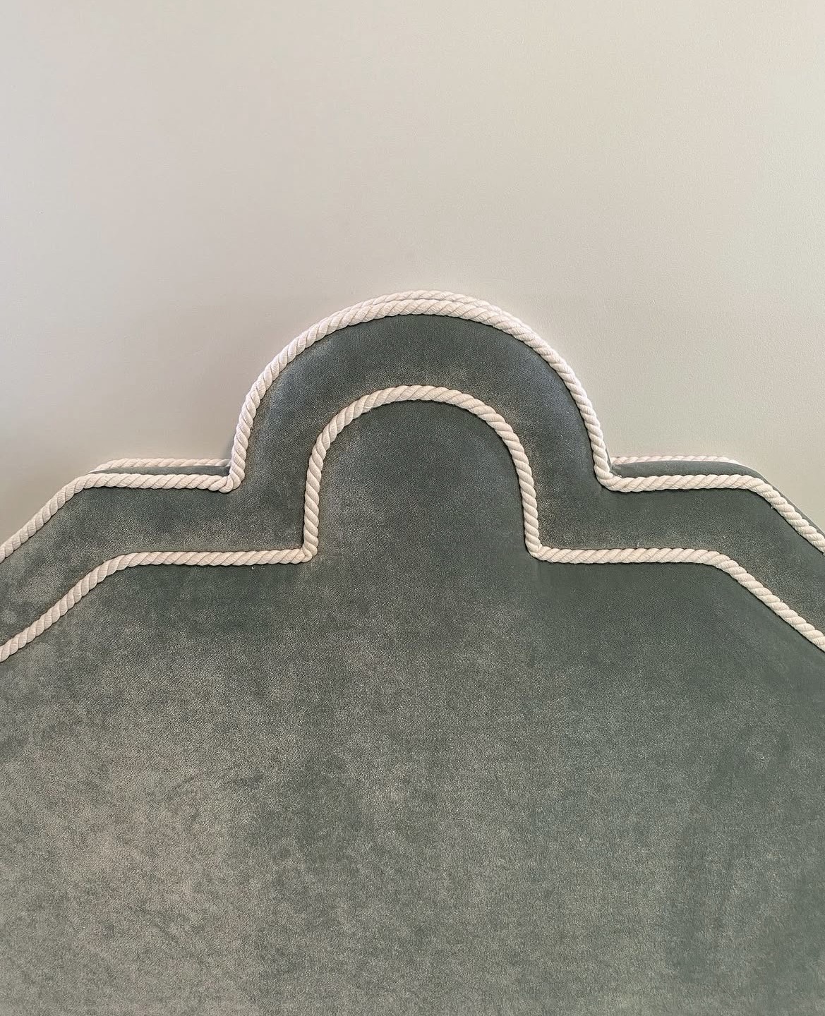 Rope piping craftsmanship close-up — shaped scalloped top edge of built-in banquette