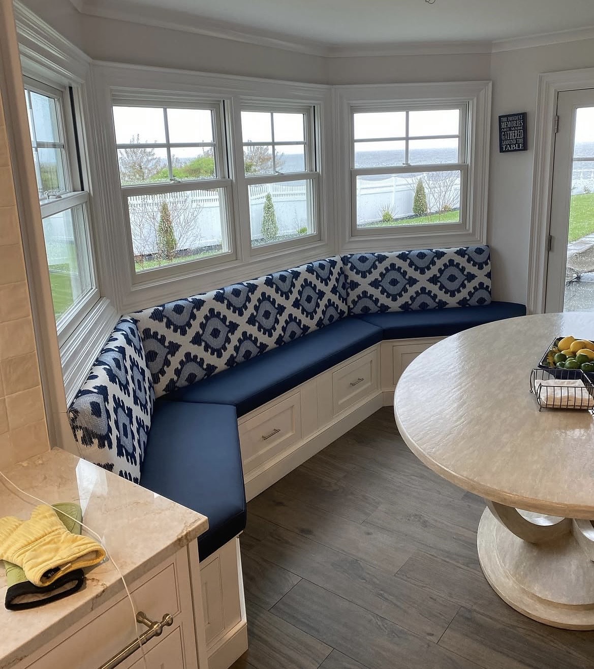 Bay window banquette reupholstery — L-shaped seating in navy ikat fabric, Long Island residential project by Fabricio's Upholstery Shop