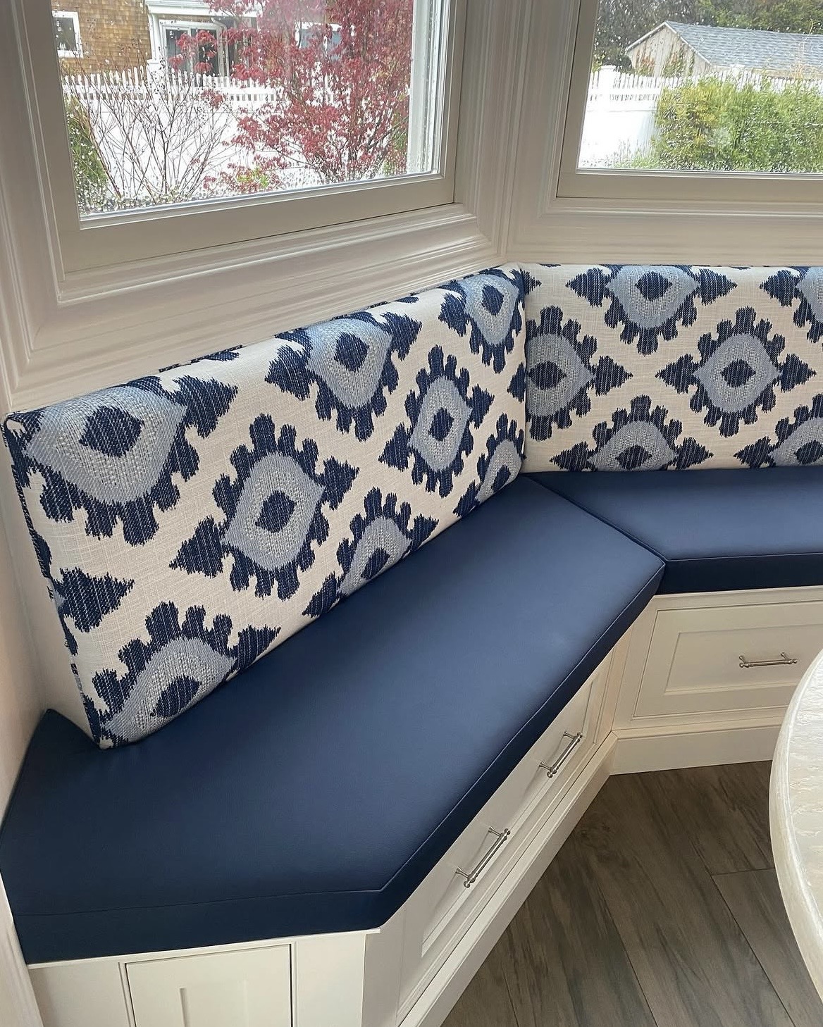 Bay window banquette cushion detail — ikat pattern matched continuously across all three back cushions, Bellport NY upholstery