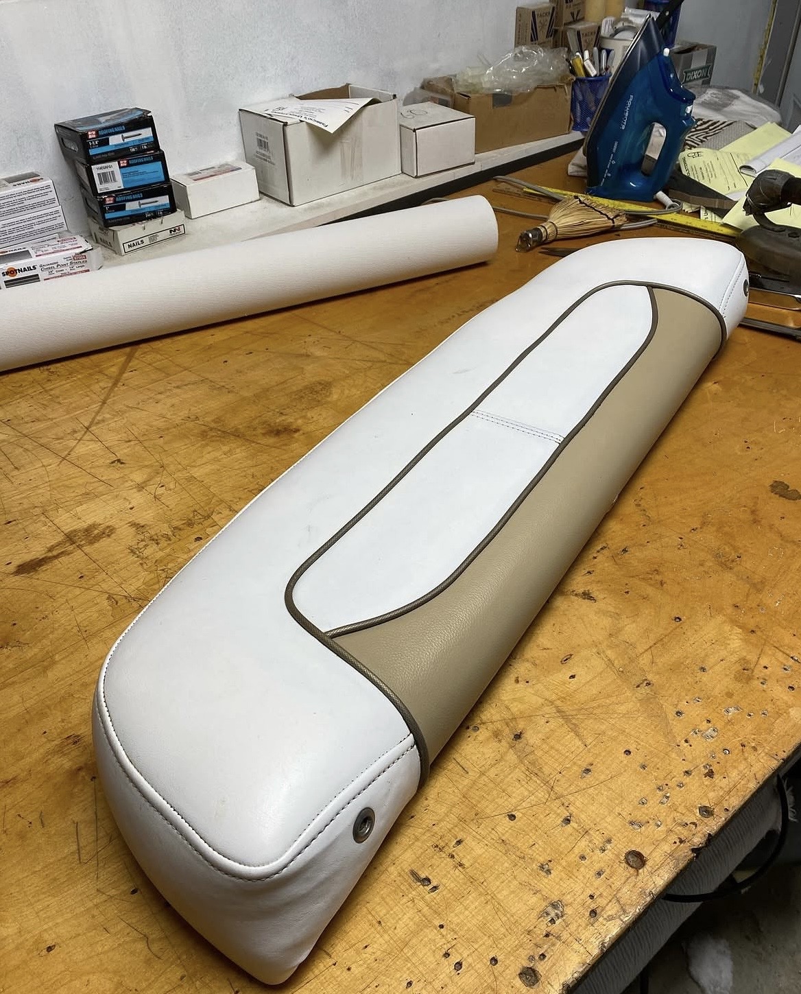Marine boat seat cushion — two-tone white and tan vinyl with contrast piping, hand-cut at Fabricio's Upholstery workshop Bellport NY