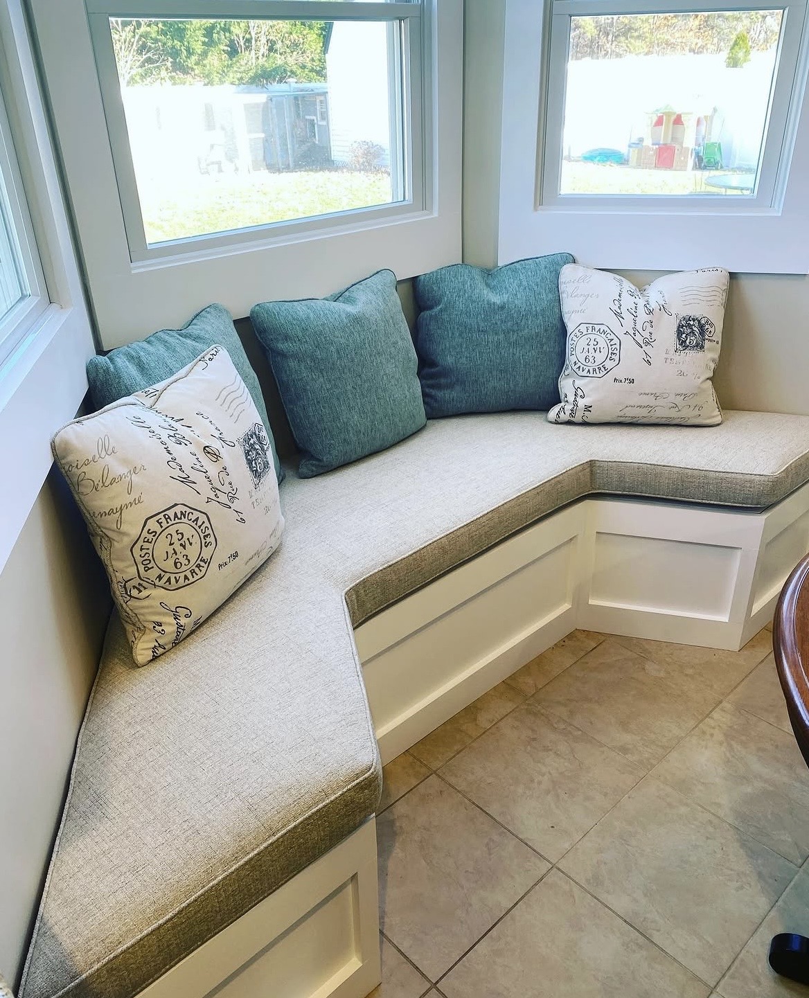 Custom window seat banquette after upholstery — finished cushions and pillows installed to exact room dimensions, Suffolk County NY
