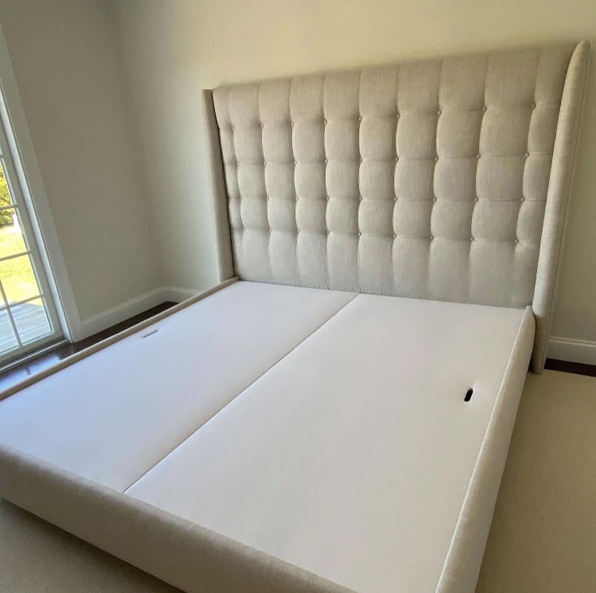Finished custom upholstered bed — tufted headboard and upholstered base, cream linen